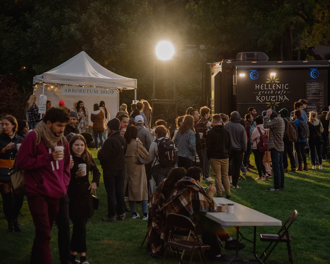 A crowd gathered at a food truck event at night