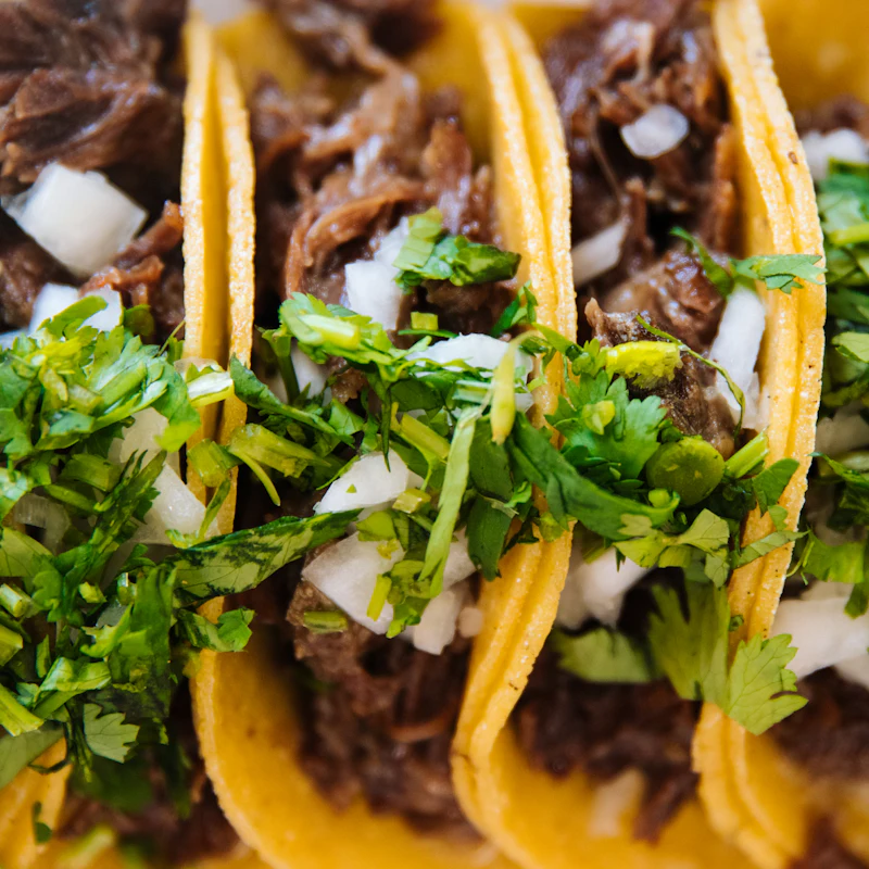 Brisket tacos topped with onion and cilantro