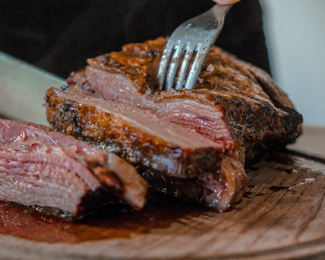 Slicing smoked brisket on a wooden board